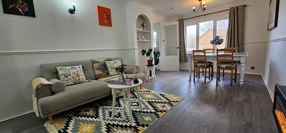Living and dining area with a patterned rug and sofa