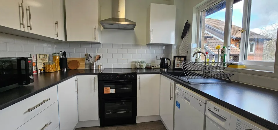 Kitchen with white cabinets, oven and hob
